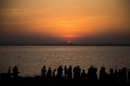 夕阳下海滩人群剪影图片