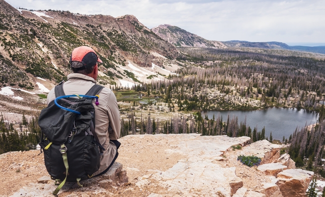男人背包旅行坐在山顶看风景图片