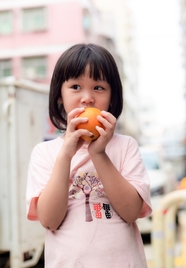 正在吃橙子的小女孩图片