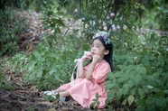 小女孩穿着粉色裙子坐在树下图片