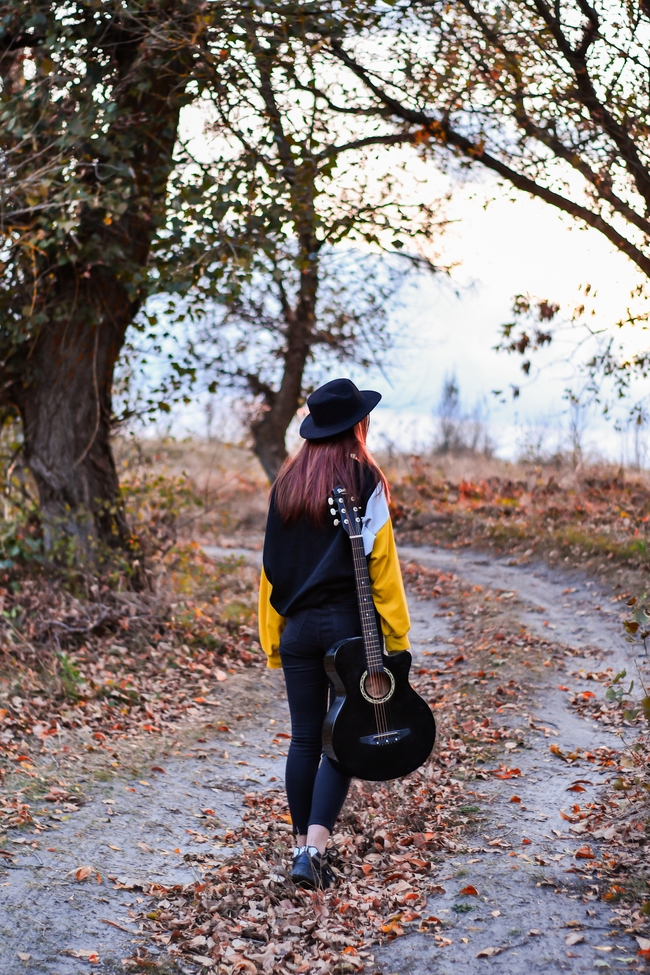 秋季户外漫步美女背着吉他背影图片