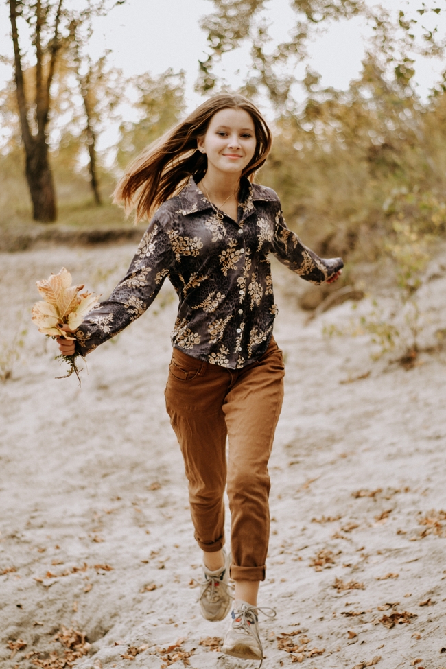 秋天手持黄叶奔跑的少女美女图片