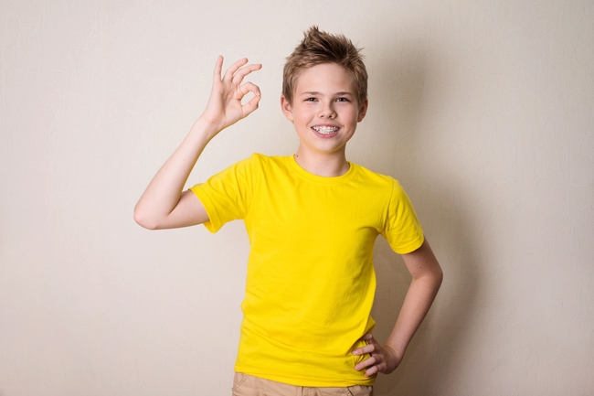 黄色T恤少年手摆OK手势图片