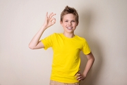 黄色T恤少年手摆OK手势图片