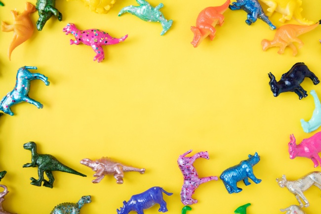 玩具恐龙黄色背景图片