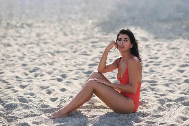 穿着泳装的美女坐在沙滩上图片