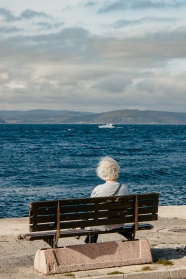 坐在海边长凳上的老奶奶背影图片