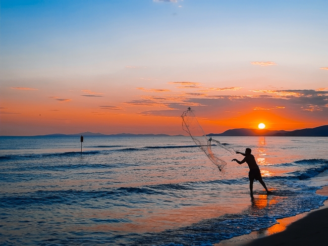黄昏日落海边渔夫图片