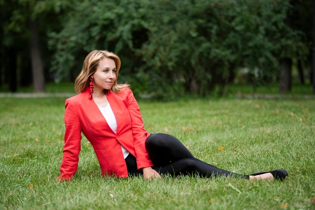 坐在公园草地上的红色西装美女图片