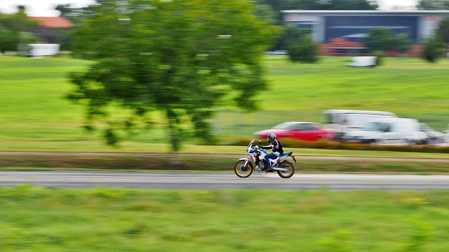 郊区公路上高速行驶的摩托车手图片