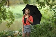 站在河边草丛撑伞的美女图片