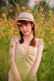 站在花海丛中戴草帽的美女图片