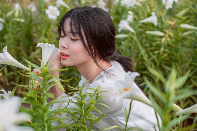 清新女孩站在花丛中闻花香图片