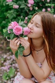 手持鲜花闻花香的侧颜美女图片