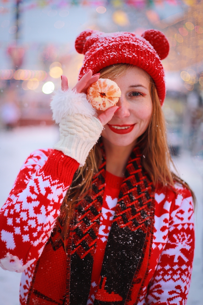 冬天手持橘子开心快乐的戴帽美女图片