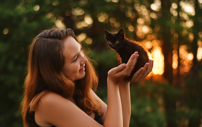 欧美美女手里捧着只小黑猫图片