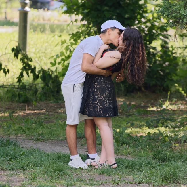 户外草地接吻的年轻情侣图片