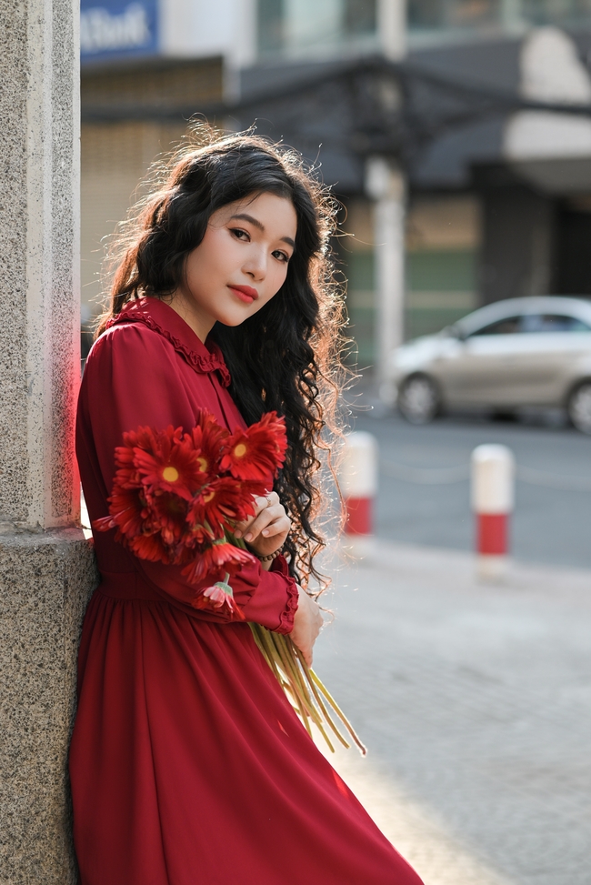站在街头手捧花束的红裙美女图片