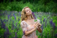 花丛手持紫色薰衣草花的美女图片