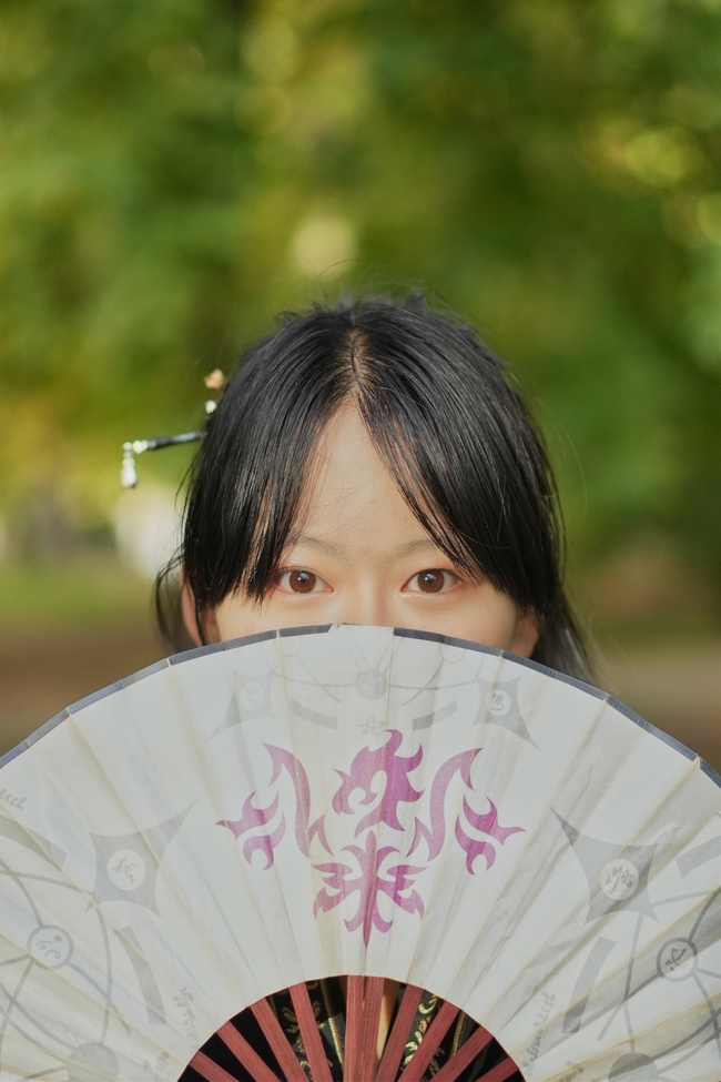 手持折扇遮挡面部的亚洲美女图片