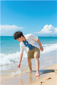 夏日海边踏浪戏水的男孩图片