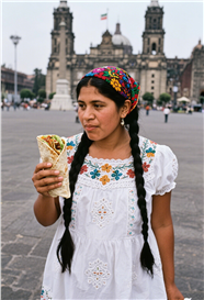 广场双麻花辫美女手持手抓饼图片