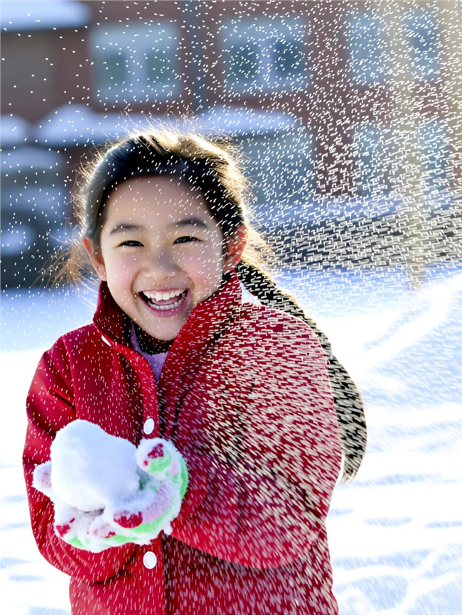 冬季雪地搓雪球的小女孩图片