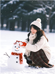 冬季白色雪地堆雪人的女孩图片