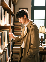 复古书店书架前的风衣帅哥图片