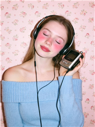 脸红闭着眼睛聆听音乐的美女图片