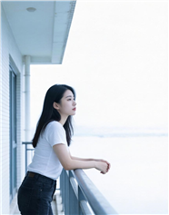 白色T恤美女倚栏眺望大海图片