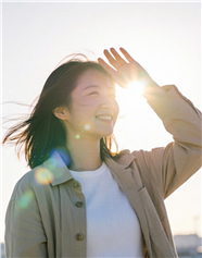 抬起手遮挡阳光的女孩图片