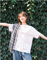 站在绿植墙前的白色T恤美女图片