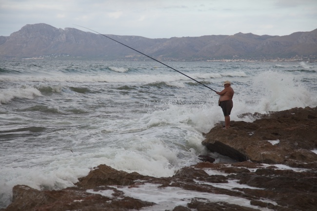 男胖子海边钓鱼图片