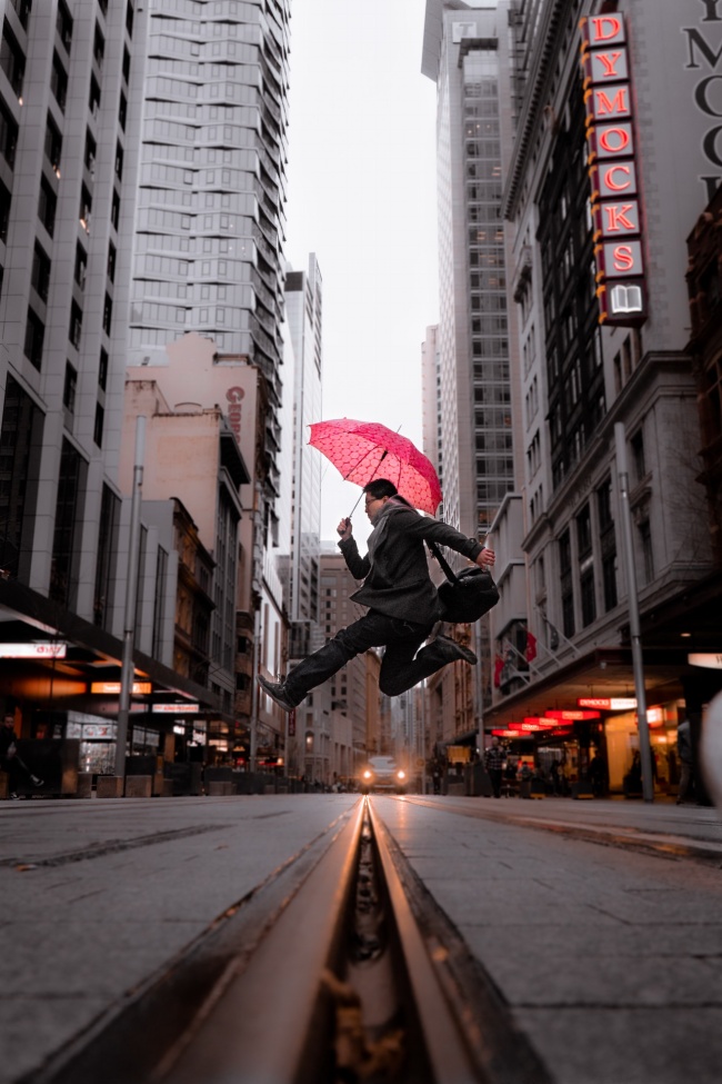 撑伞跳跃男业务员图片