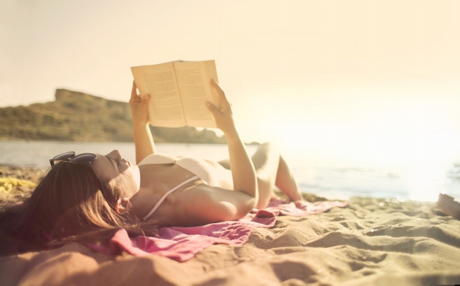 躺在沙滩上看书的美女图片