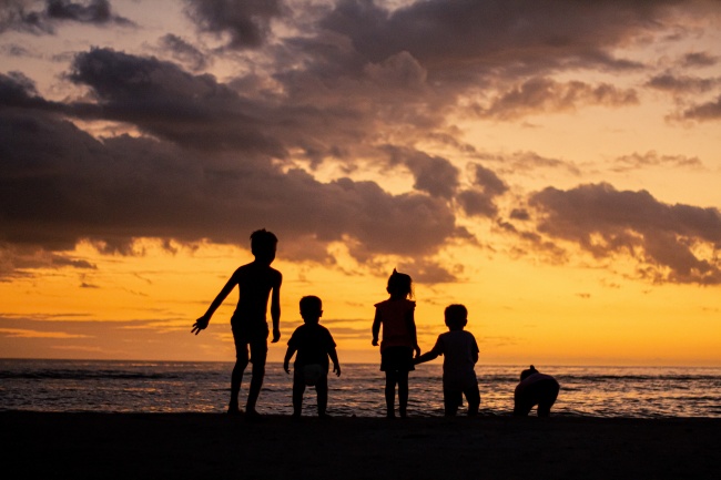 日落时海滩上孩子们剪影图片