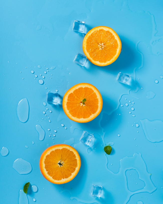 鲜橙冰块蓝色背景图片