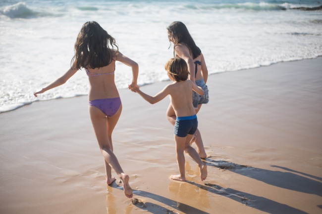 三个孩子在沙滩上玩乐图片